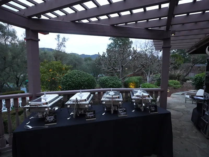 Dinner buffet set under a pergola at dusk overlooking the hills near Hercules