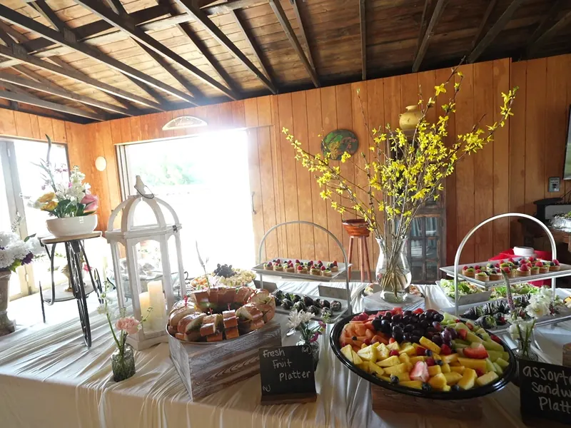 Brunch spread of pastries, fresh fruit and sandwich platters with chalkboard signs at an Emeryville event