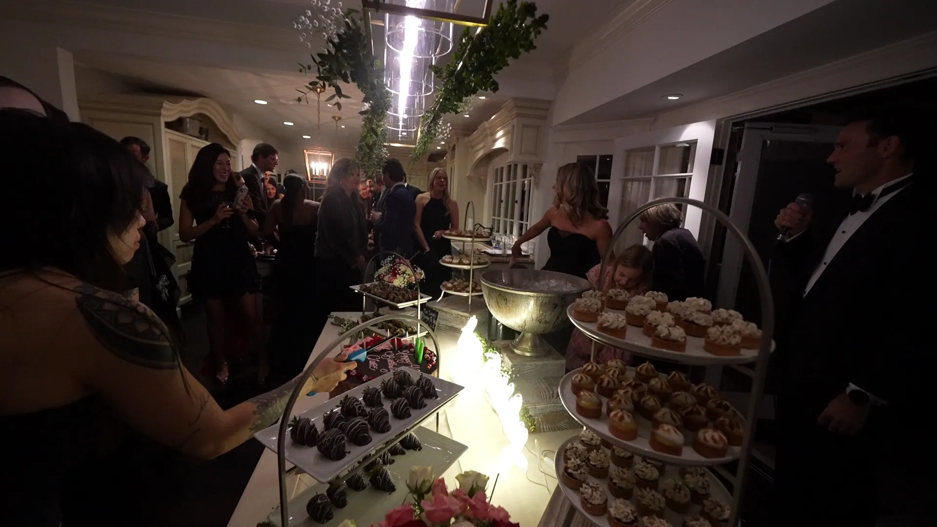 Guests gathered around tiered desserts at an El Sobrante house celebration