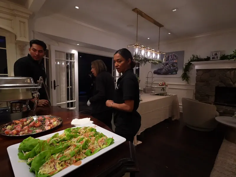 Catering team working chafing dishes and platters in the kitchen at a Piedmont home dinner