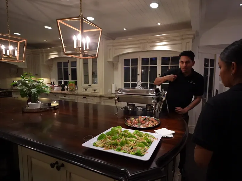 Catering staff plating appetizer platters on the kitchen island at an El Sobrante home event