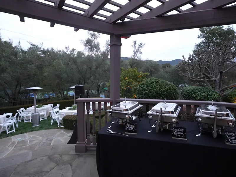 Chafing-dish buffet set under a pergola with the East Bay hills behind it near Pinole