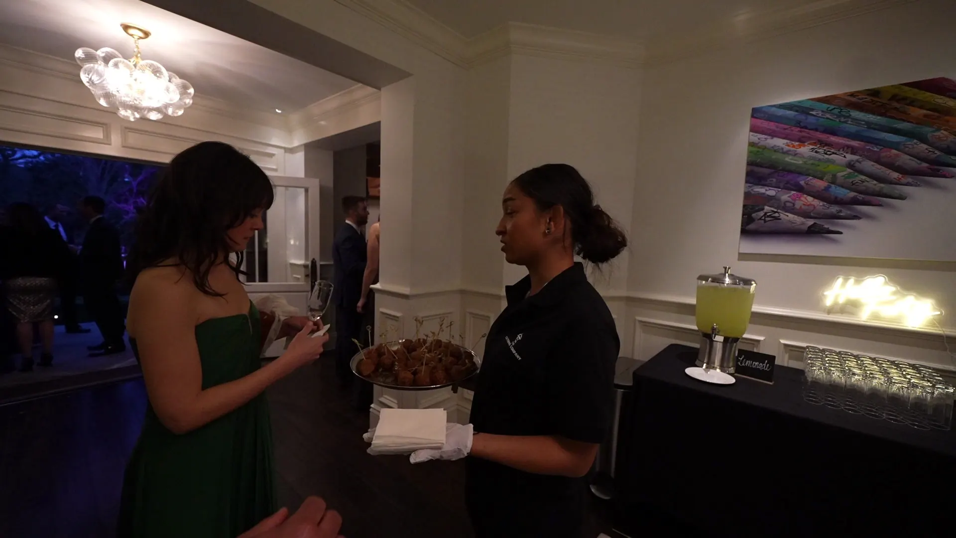 Catering server passing a tray of warm appetizers to guests at an Oakland cocktail reception