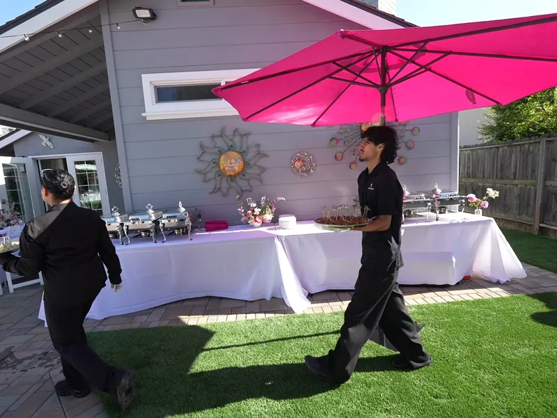 Catering staff finishing a lawn buffet before guests arrive at an Emeryville outdoor event