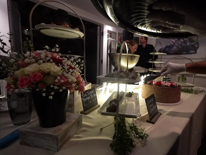 Dessert display with fresh florals, champagne and chalkboard signs at a San Pablo party