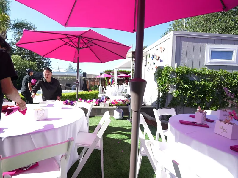 Staffed backyard buffet with umbrella tables at a Hercules family celebration