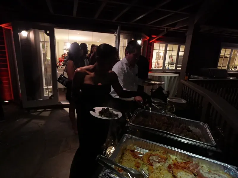 Guests plating pasta and entrees from an outdoor buffet at an El Cerrito evening event