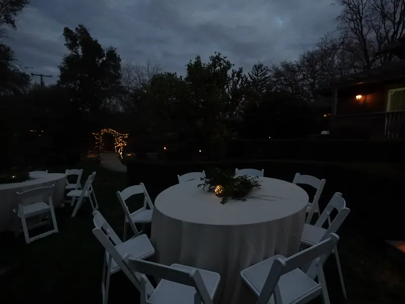 Round table with a candle centerpiece set at dusk in a San Leandro garden