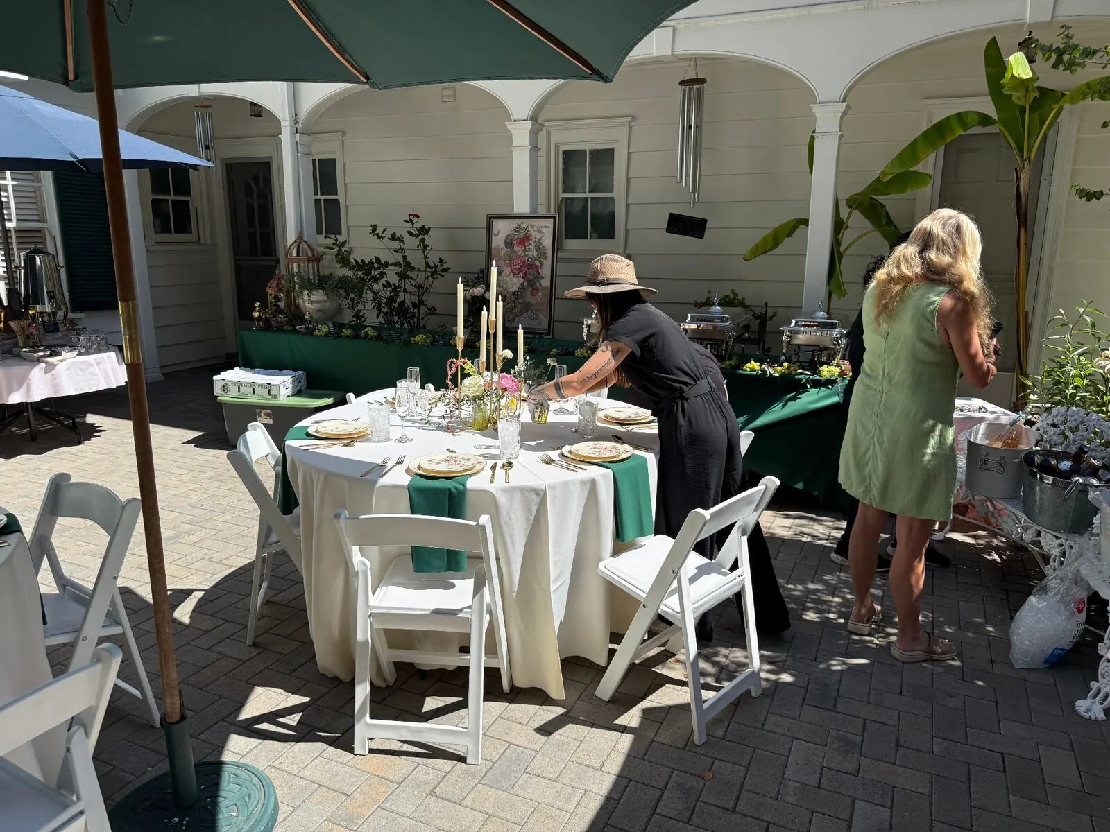 Courtyard rounds in emerald cloth with upgraded rental chairs, stemware and full settings — elevated rentals styling for Oakland catering